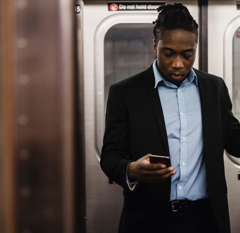 photo d'un homme dans le metro devant son téléphone