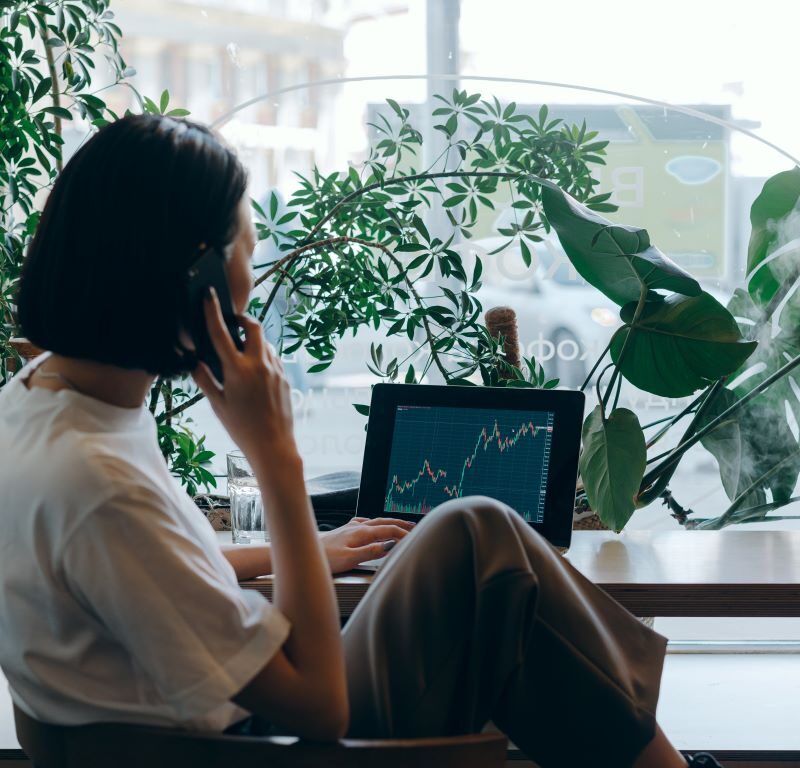 photo d'une femme devant son ordinateur et un graphique