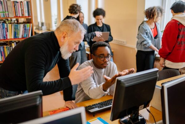 photo d'un étudiant et un professeur devant un ordinateur
