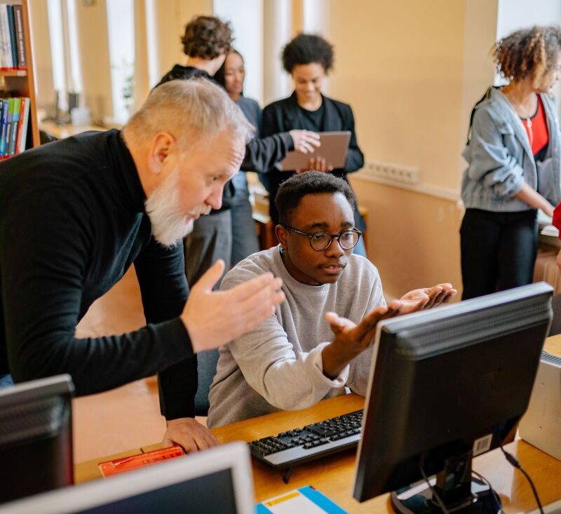 photo d'un étudiant et un professeur devant un ordinateur