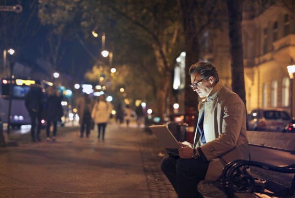 photo d'un homme devant son ordinateur dans la rue